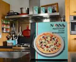 Nonna Pizzasteen Ø30,5 Met RVS Serveerrek - Stenen Pizzaplaat / Ovenplaat (11mm Dik) Voor Oven En Barbecue (BBQ) - Maximaal 600 Graden Celcius -Barbecuebenodigdheden 1200x985 2